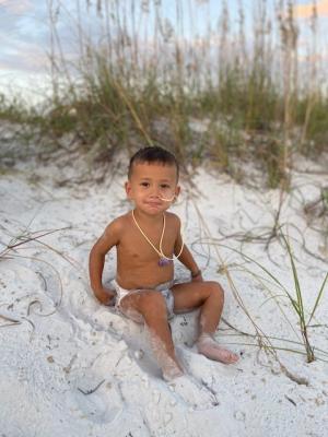 Toddler sitting in sand at the beach
