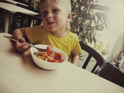 Child eating a bowl of fruit