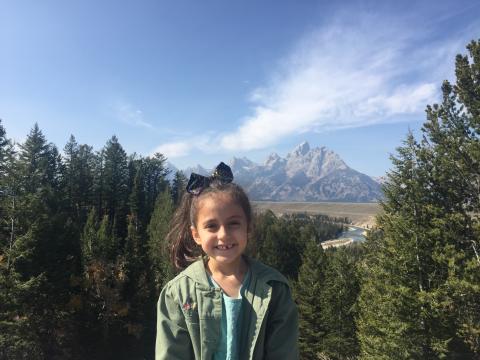 Girl smiling in front of mountain background