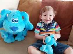 Toddler sitting with two dog plushies