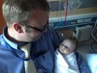 Father holding infant in hospital