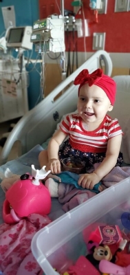 Toddler in hospital bed smiling