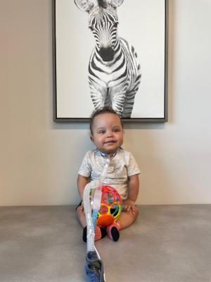 Baby sitting in front of zebra photo