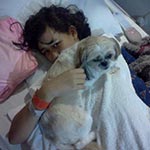 Girl with dog in hospital bed