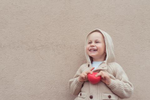Child holding a small red ball