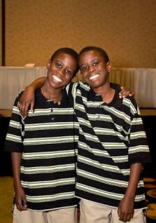 Twin boys in striped shirts with arms around each other