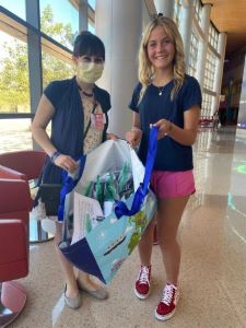Two females holding an open bag of goodies