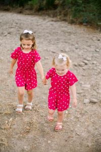 Two young girls holding hands outside