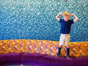 Boy on couch flexing his muscles