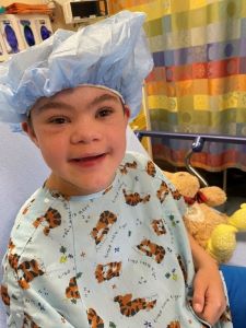 Boy in hospital gown and hair net