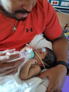 Father bottle feeding newborn