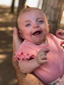 Smiling infant in pink shirt