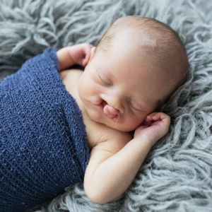 Sleeping baby with cleft palate, wrapped in blue blanket