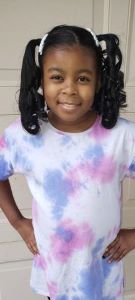 Girl with pigtails wearing tie-dyed shirt