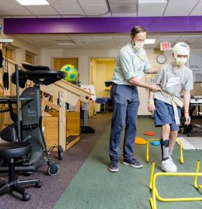 Masked patient and provider doing physical therapy