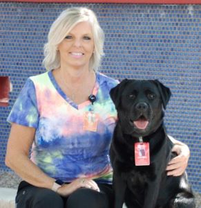 Black pet therapy dog and female handler