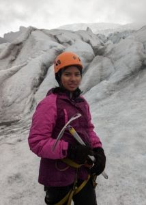 Teenage mountain climber in pink jacket and orange helmet