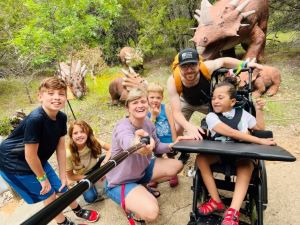 Family of 6 posing with dinosaurs