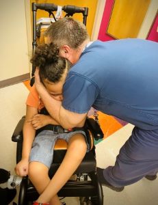 Provider hugging patient in wheelchair