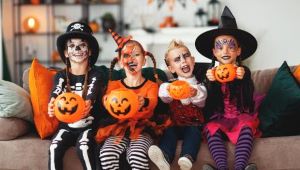 Kids dressed for Halloween, holding Jack-o-Lanterns