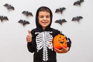 Boy in skeleton costume giving thumbs up