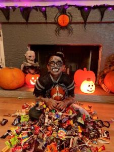 Boy in costume surrounded by candy
