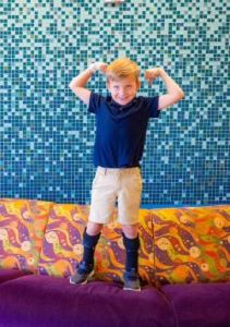 Boy with leg braces flexing his biceps