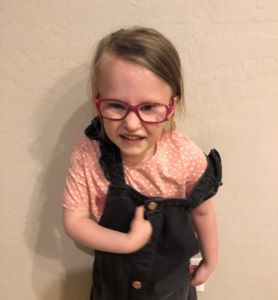 Smiling child in pink glasses