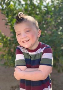 Boy with faux-hawk smiling at camera