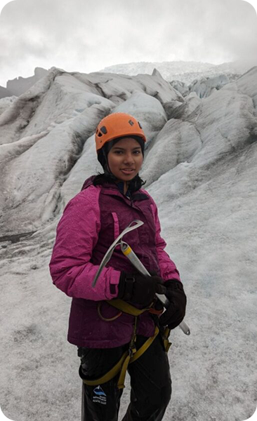 Teenage mountain climber in pink jacket and orange helmet