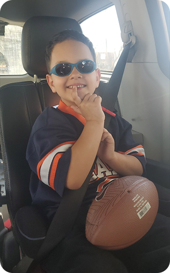 Toddler in sunglasses with football