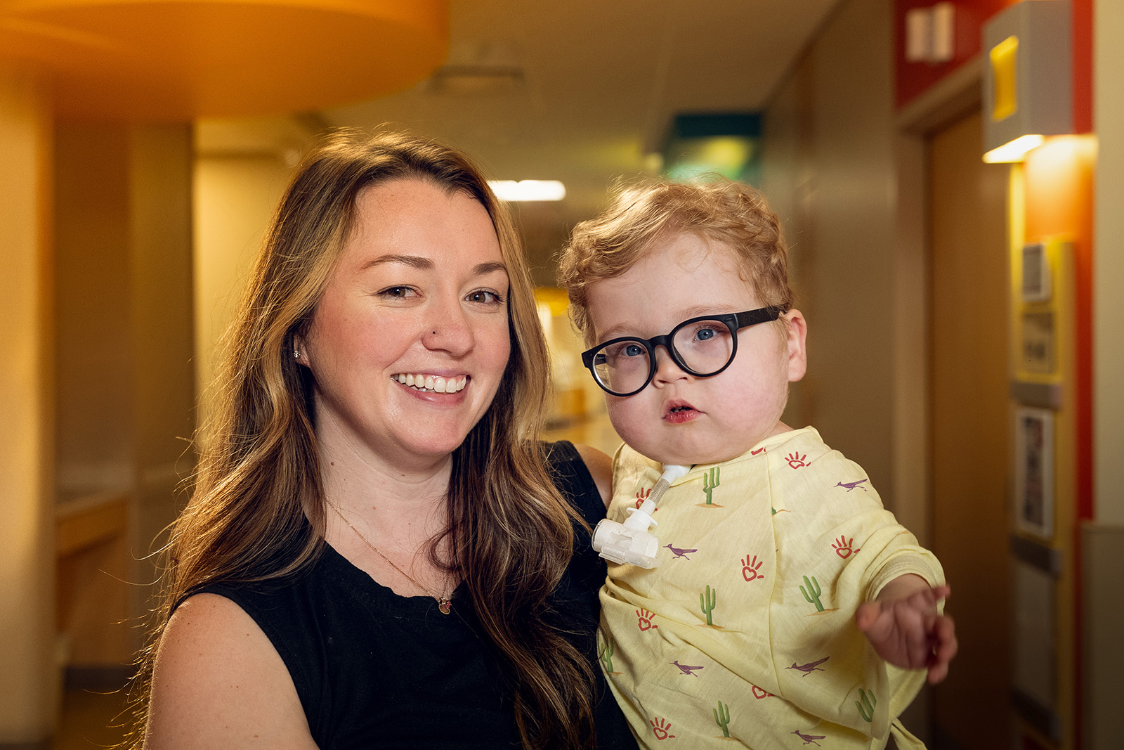 Parent holding baby boy with glasses
