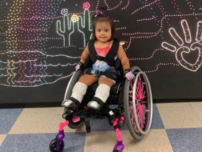 Toddler in pink wheelchair