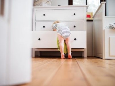 Toddler climbing into dresser drawer