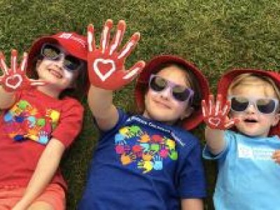 Kids laying in grass showing painted hands