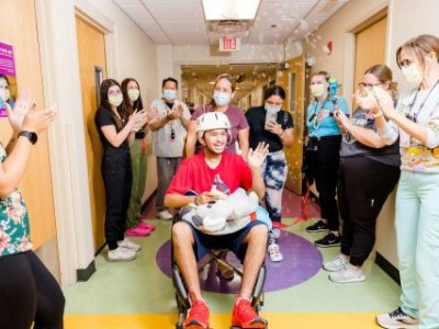 Patient in wheelchair celebrating as they leave hospital
