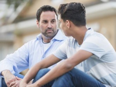 Father and teen son talking