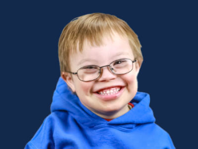 Boy in glasses and blue sweatshirt, smiling at camera