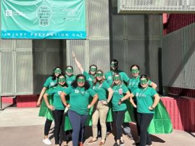 Care Team wearing green shirts, capes and masks