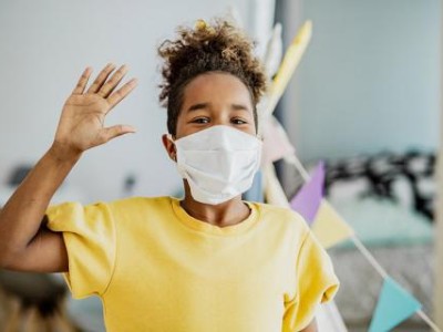 Masked kid waving at camera