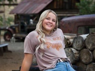 Teen girl sitting on truck bed