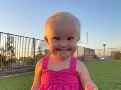 Toddler in pink top smiling at camera