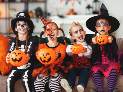 Kids dressed for Halloween, holding Jack-o-Lanterns