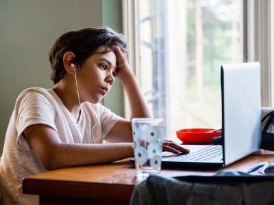 Child studying at home with laptop