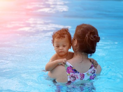 Mother holding infant in pool