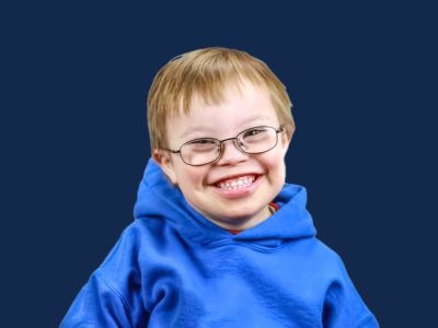 Boy in glasses and blue sweatshirt, smiling at camera