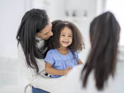 Smiling little girl with parent and provider