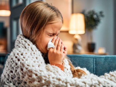 Young girl blowing her nose