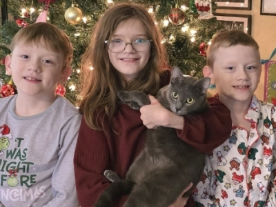 Siblings in front of holiday tree