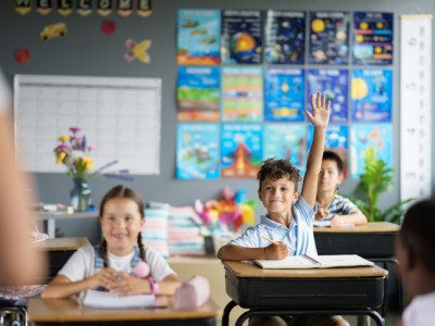 Child raising hand in classroom